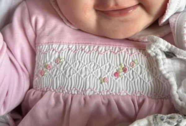 Baby girls pink smocked baby grow